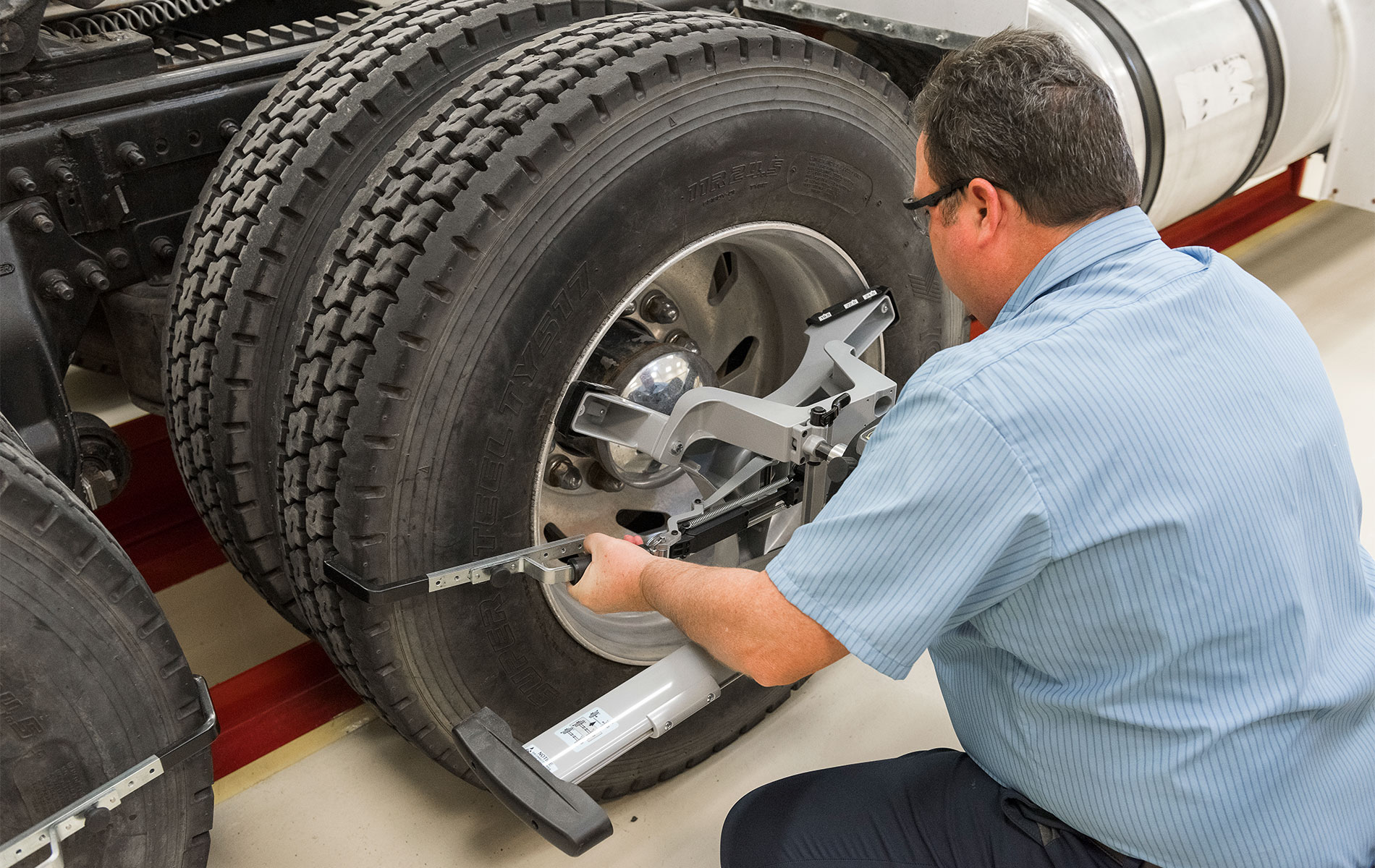 Heavy-Duty QuickGrip® Alignment Adaptors Man attaches Hunter HD QuickGrip® on tires of a semi